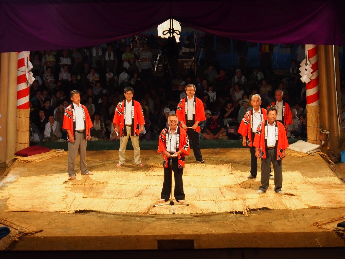 オレンジの上着を着た人たちが並んでいる写真