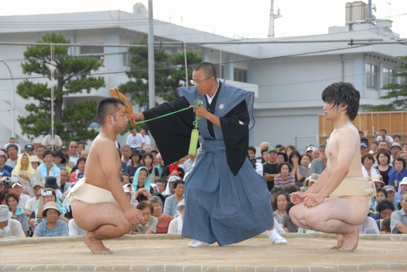 土俵の上でしゃがんで向き合う二人の褌姿の男性の写真