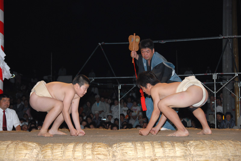 白い回しを付けた力士2人が土俵上でにらみ合っている写真