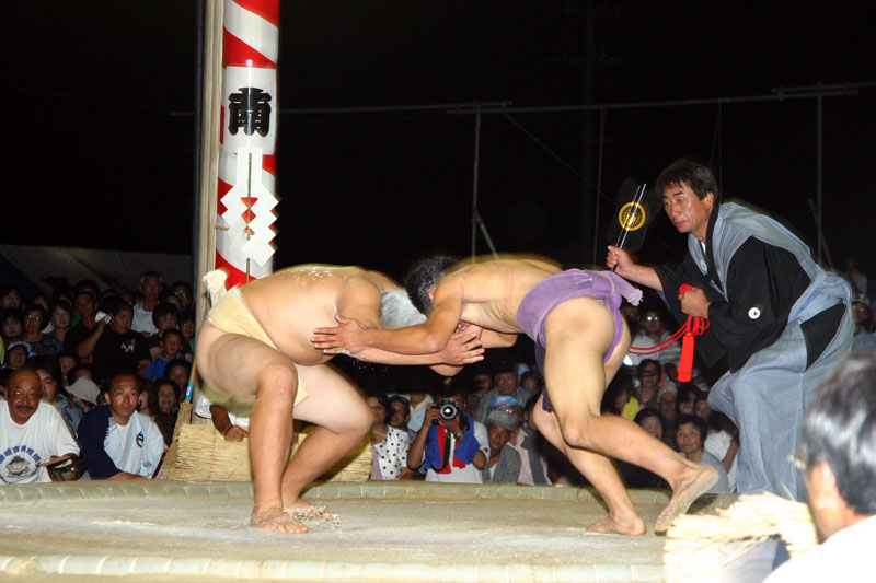 頭を下げてぶつかりに行く力士2人の写真