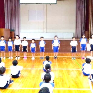 学年代表の児童たちがみんなの前で目当てを発表している写真