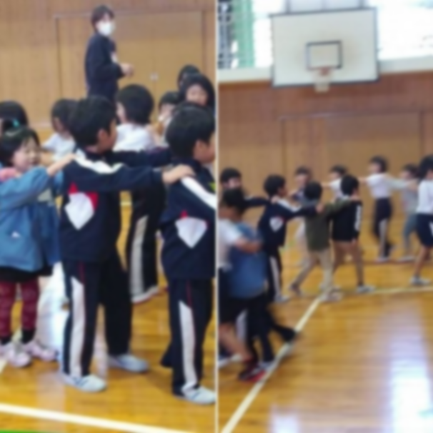 体育館で児童たちが前の人の肩に手をに乗せて連なって歩いている写真