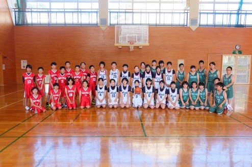 バスケットボールの各ユニフォームを着た3チームが並んで記念撮影をしている写真