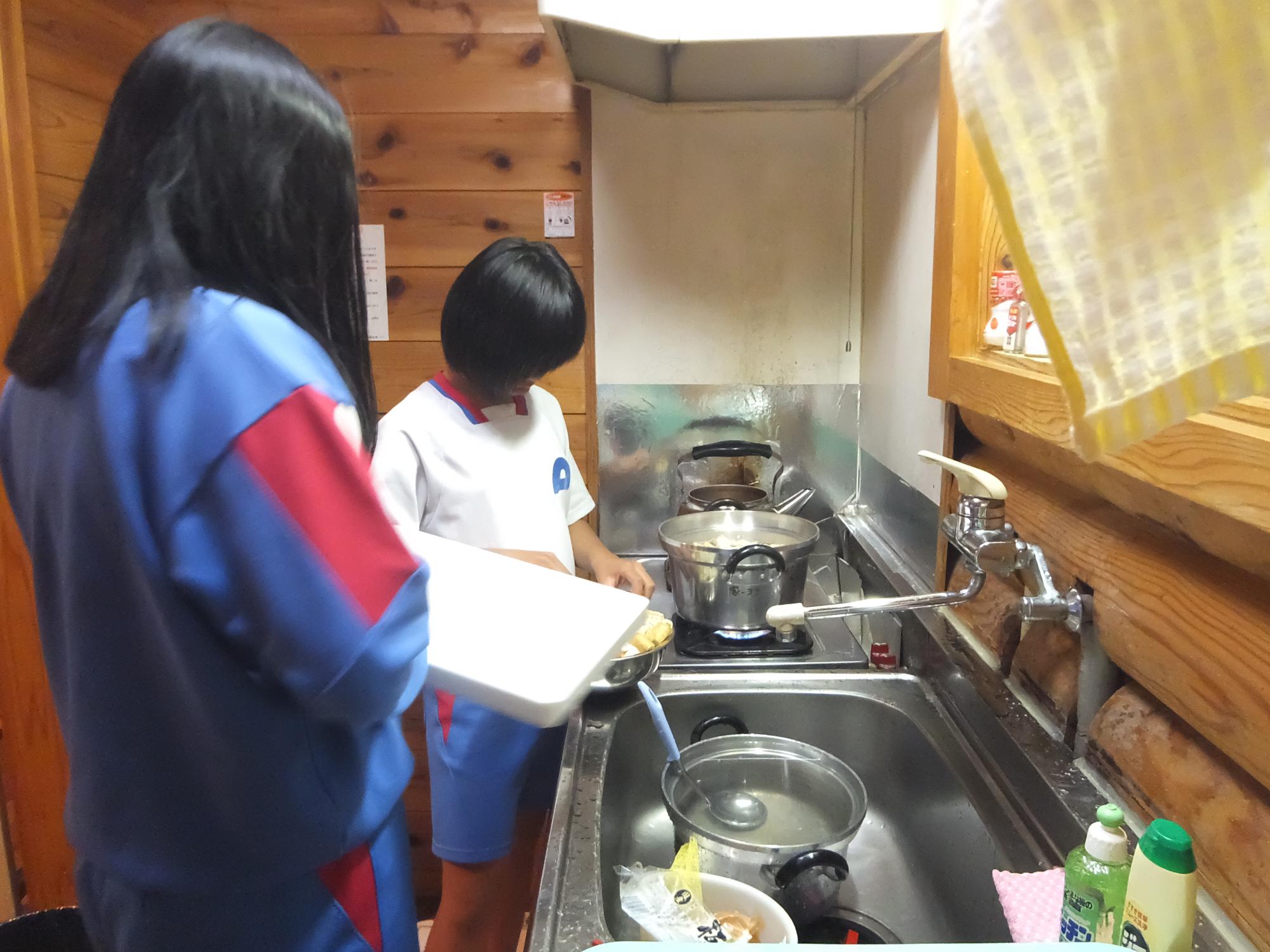 台所で2人の女子児童が洗い物を行っている写真