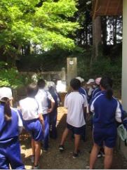 古い建物の陰に立っている児童たちの写真