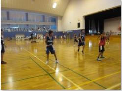 体育館で児童たちがバスケの試合をしている写真