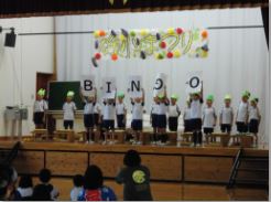 舞台で児童たちが文字を掲げ発表している写真