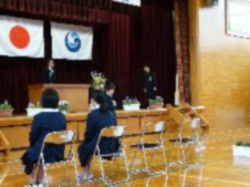 体育館で卒業式に臨む卒業生の後ろ姿の写真