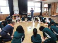 練習用人形で心肺蘇生法の練習をしている児童たちの写真
