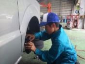 職場体験学習で車修理工場で生徒が車の整備の作業をしている写真