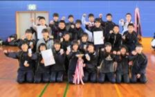 生徒たちが賞状やトロフィーを手にして集まり、全員でポーズを取っている写真