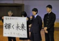 生徒がスローガンが書かれた紙を掲げたり、マイクを持って話している写真