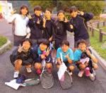 屋外で、ラケットを持った生徒たちが集まり、ポーズを取っている写真