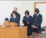 生徒が壇上でマイクに向かい原稿を読み上げている写真