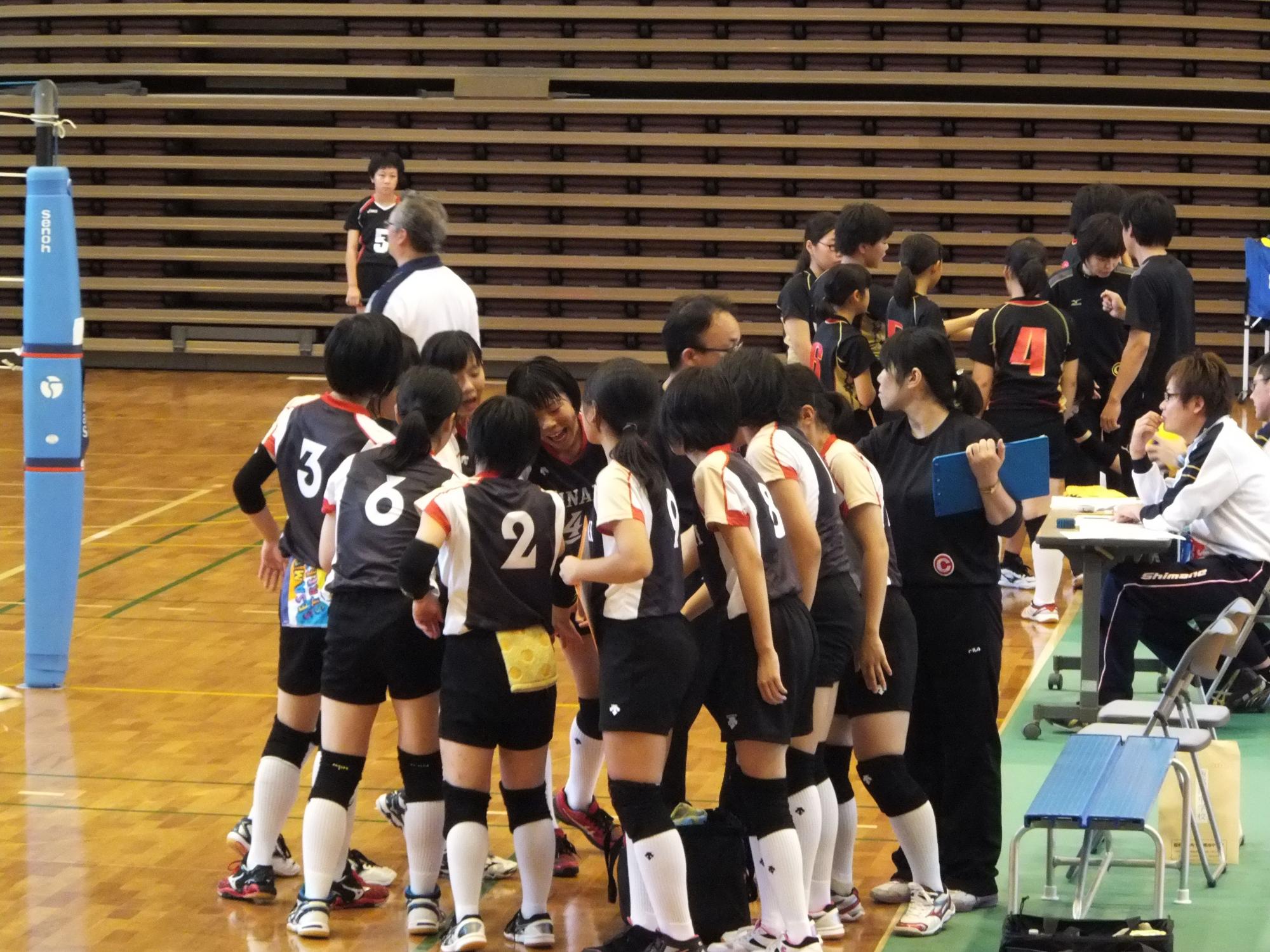 ユニフォーム姿の生徒が円を作り、試合前に声を掛け合っている写真