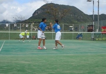 ソフトテニスのダブルスの試合で二人でハイタッチをしている写真