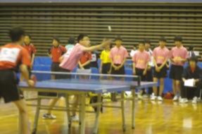 応援を受けながら卓球の試合をしている生徒の写真