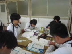 生徒たちがグループを作って、資料に書き込みながら話し合いをしている写真