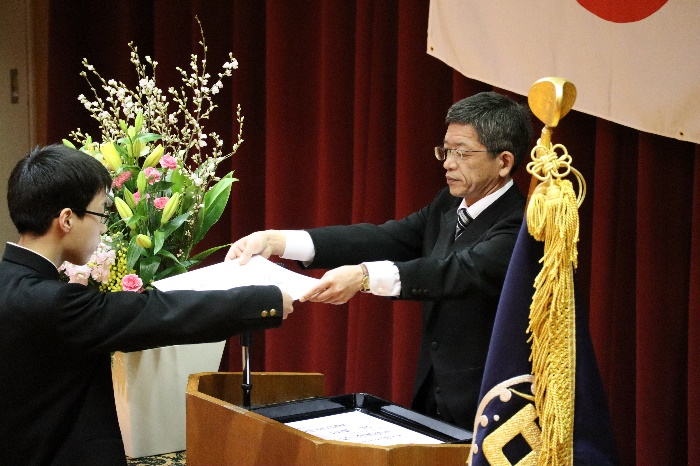 校長先生から卒業証書を受け取っている生徒の写真