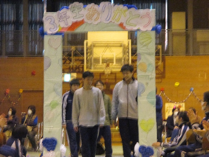 「3年生ありがとう」と書かれたゲートを生徒が通っている写真