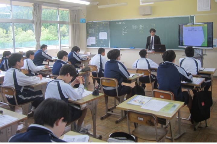 自席で先生の話を聞いている生徒たちの写真