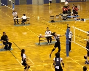 体育館でバレーボールの試合する女子生徒の写真