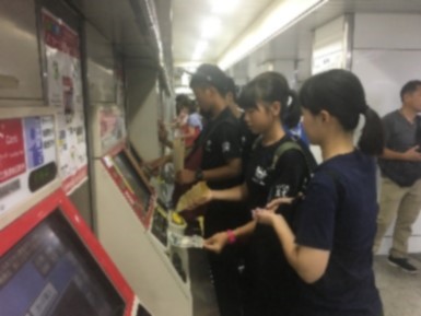 券売機で切符を購入している生徒たちの写真