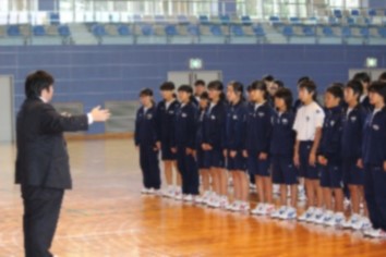 体育館のフロアで合唱の練習をしている生徒たちの写真