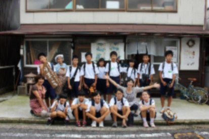 建物の前に並んで記念撮影している生徒たちの写真