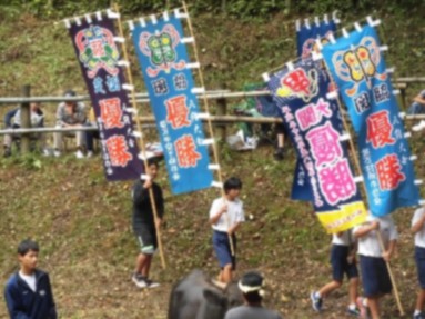 のぼり旗を一本ずつ持って歩いている生徒たちの写真