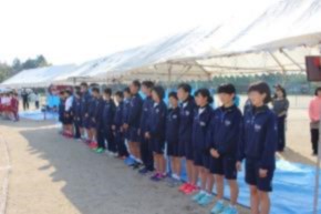 運動着姿の学生たちがテントの前に横一列で並んでいる写真