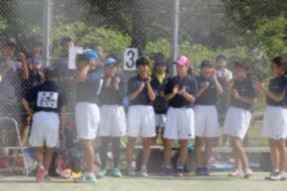 テニスウェアの生徒たちが選手を応援している写真