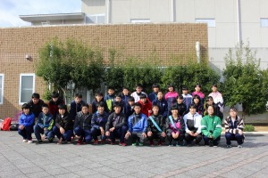 建物の前で生徒達が整列して集合写真を撮っている写真