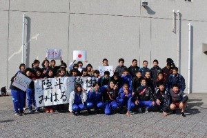 屋外で複数の生徒が横断幕を持ち、集合写真を撮っている写真