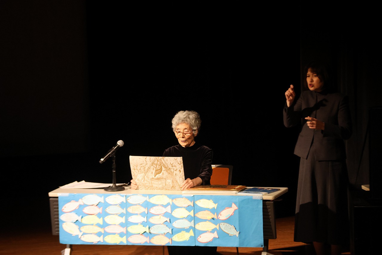 杉原由美子氏が絵本の読み着かせをしている写真