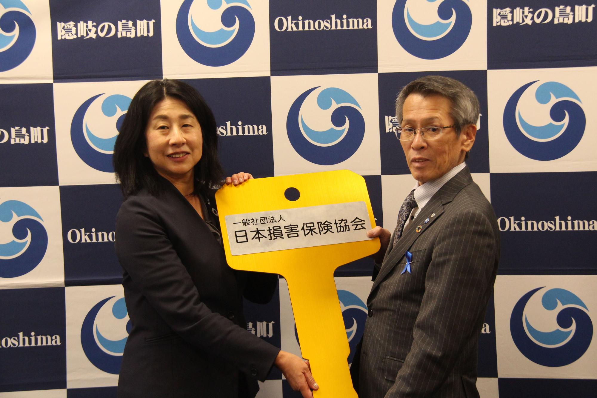 藤中会長と池田町長が並んでレプリカキーを持っている写真